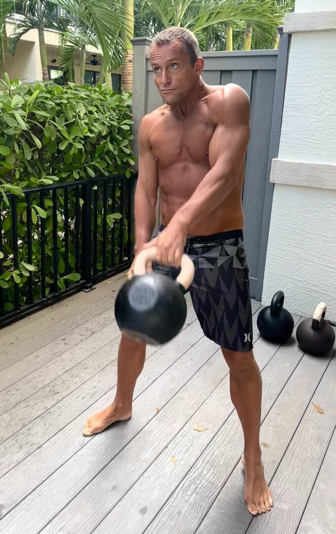 One-arm kettlebell swing training outdoors in Palm Beach Florida - functional strength coaching
